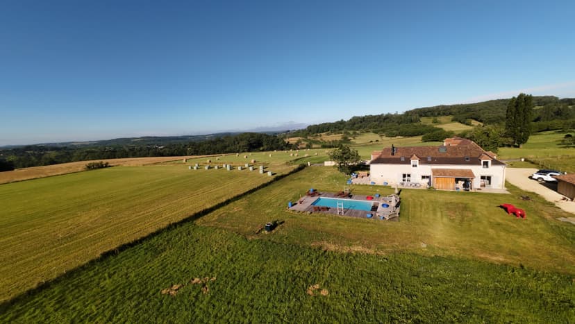 Vue aérienne d'une villa moderne avec piscine privée entourée de champs verdoyants en Dordogne
